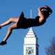 A woman dives from a platform into a giant air bed at a festival for the Rugby World Cup in New Zealand.